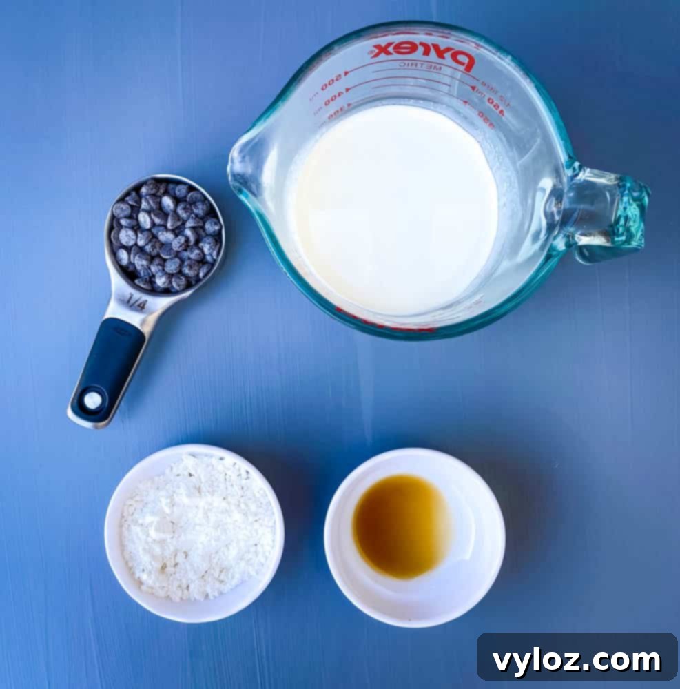 Effortless Sugar-Free Chocolate Mousse 3 Key ingredients laid out for keto low carb chocolate mousse: heavy whipping cream, sugar-free chocolate chips, vanilla extract, and powdered sweetener