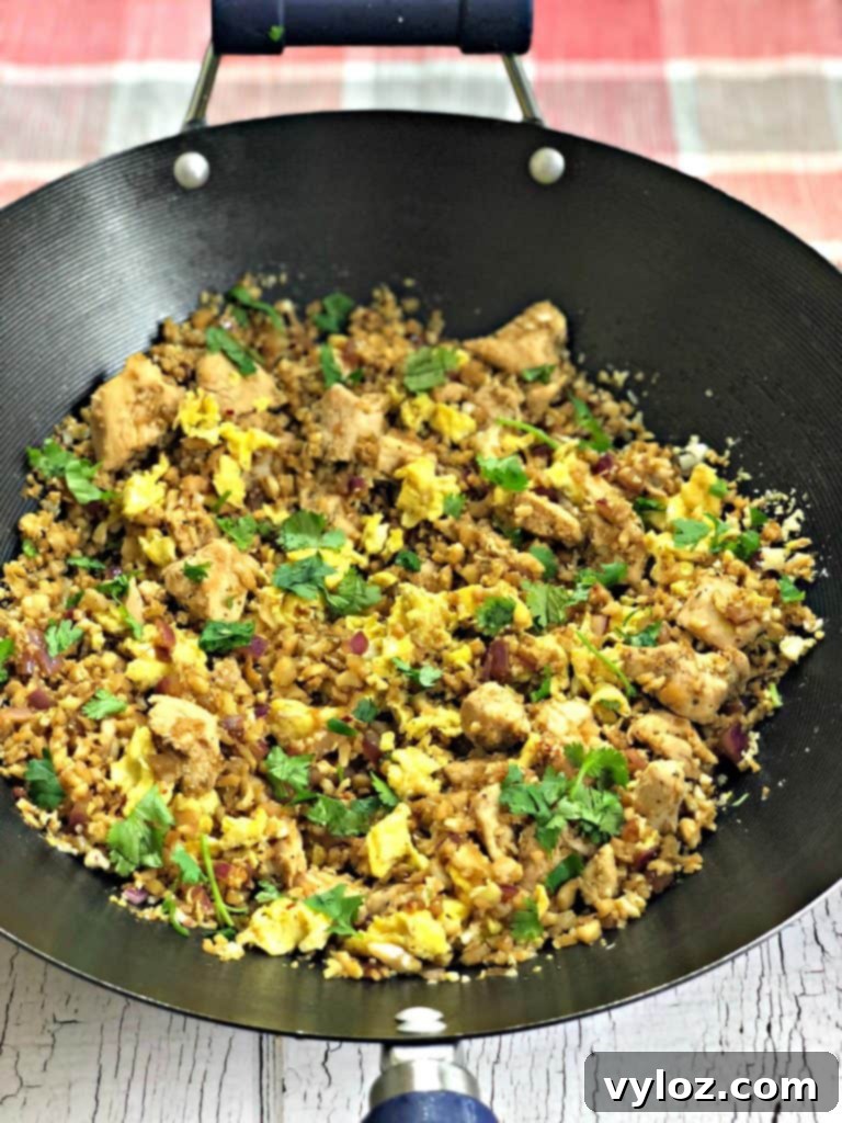 A vibrant serving of Keto Low-Carb Cauliflower Chicken Fried Rice with shrimp as an alternative protein option, garnished with fresh herbs