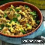Low-Carb Paleo Cauliflower Vegetable Fried Rice with Chicken in a serving dish, garnished