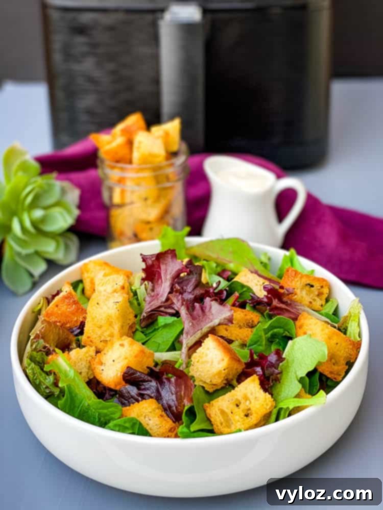 Crispy Air Fryer Croutons 2 Crispy air fryer croutons topping a fresh green salad in a white bowl