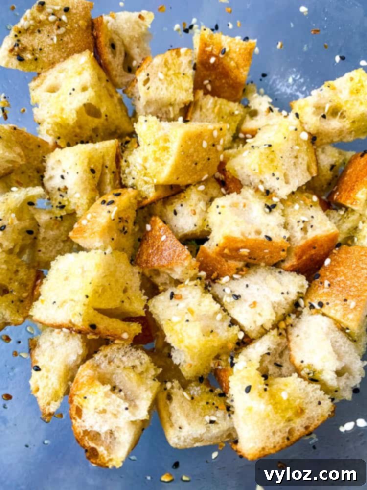 Crispy Air Fryer Croutons 6 Cubed sourdough bread in a clear glass bowl, seasoned with olive oil and spices, ready for the air fryer