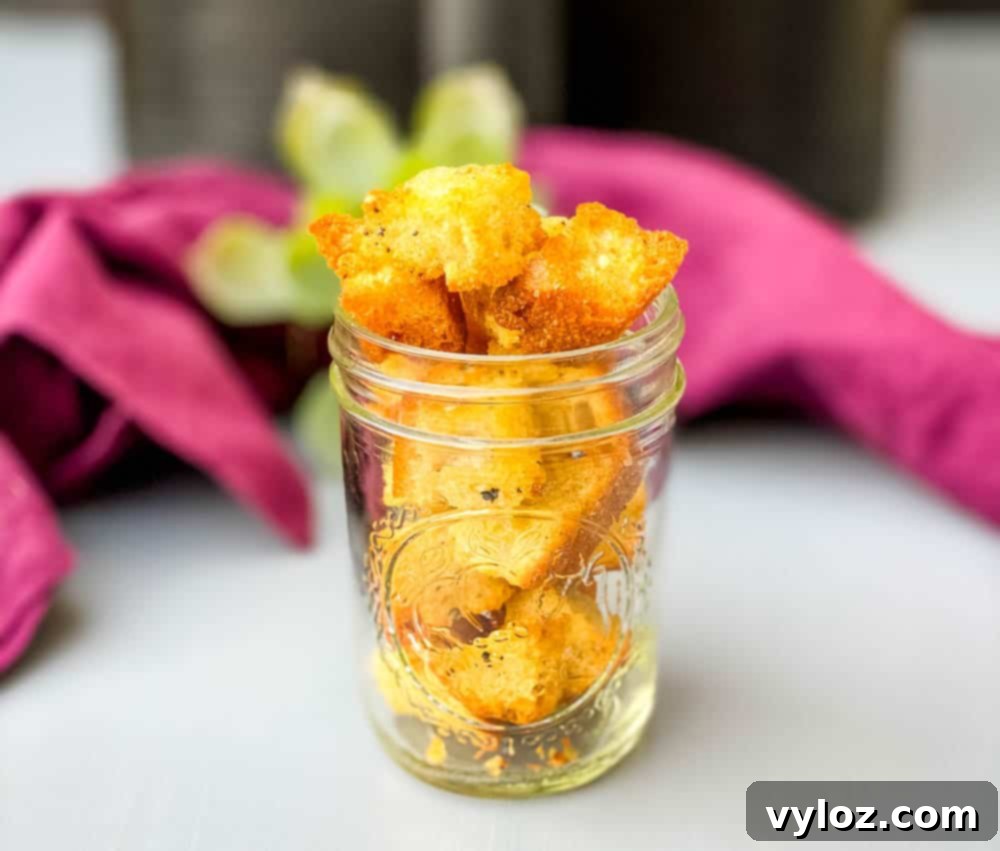 Crispy Air Fryer Croutons 10 Homemade air fryer croutons stored in a clear glass jar on a wooden surface