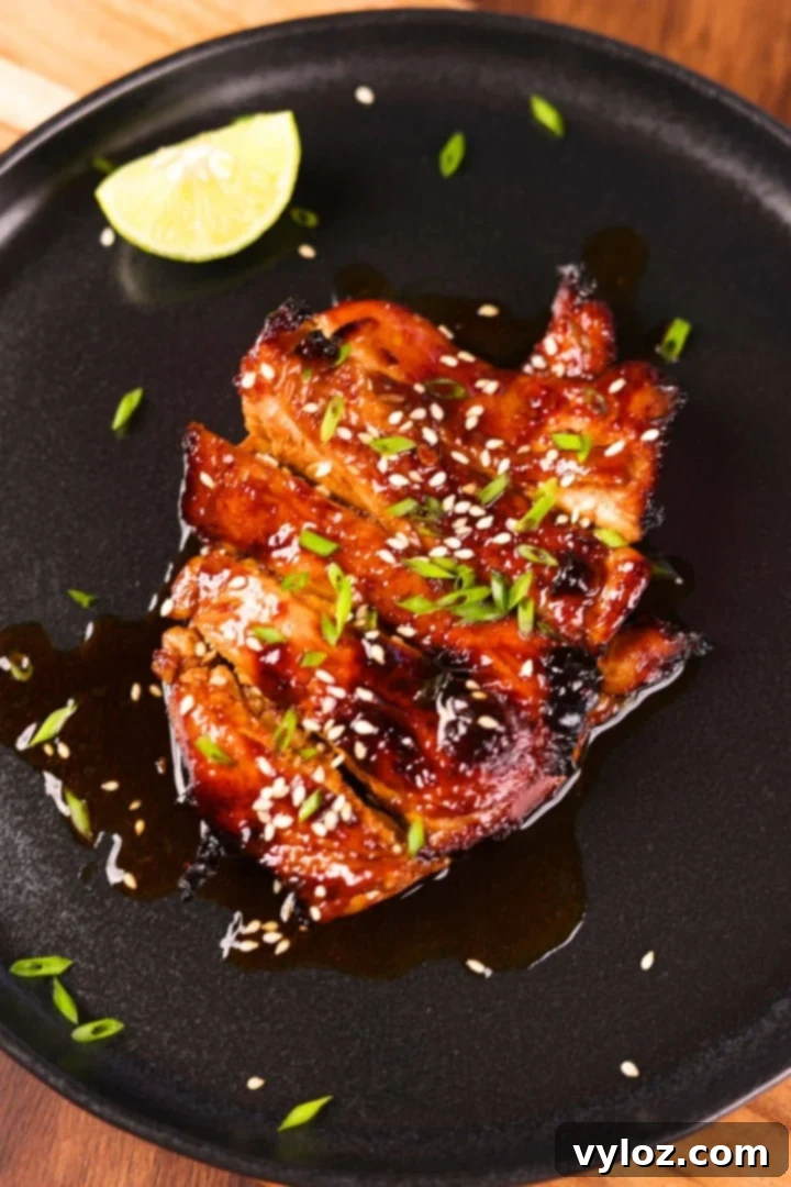 Restaurant-style Asian chicken marinade served on a black plate with garnishing for a flavorful meal.