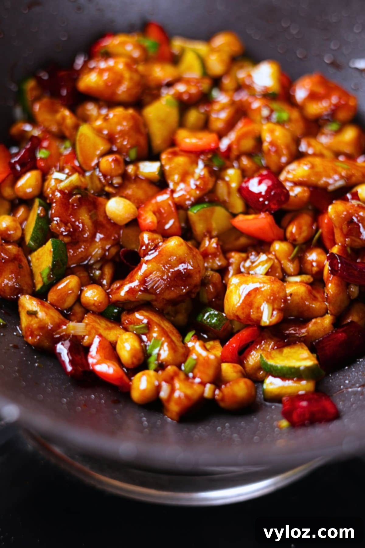 Kung pao chicken quoted in a glossy sauce with peanuts and dried red chilies.