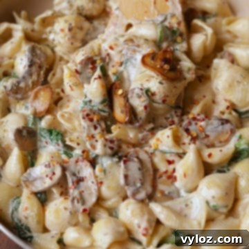 Velvety Mushroom and Spinach Pasta 8 Creamy mushroom and spinach pasta in an off-white pan, garnished with herbs.