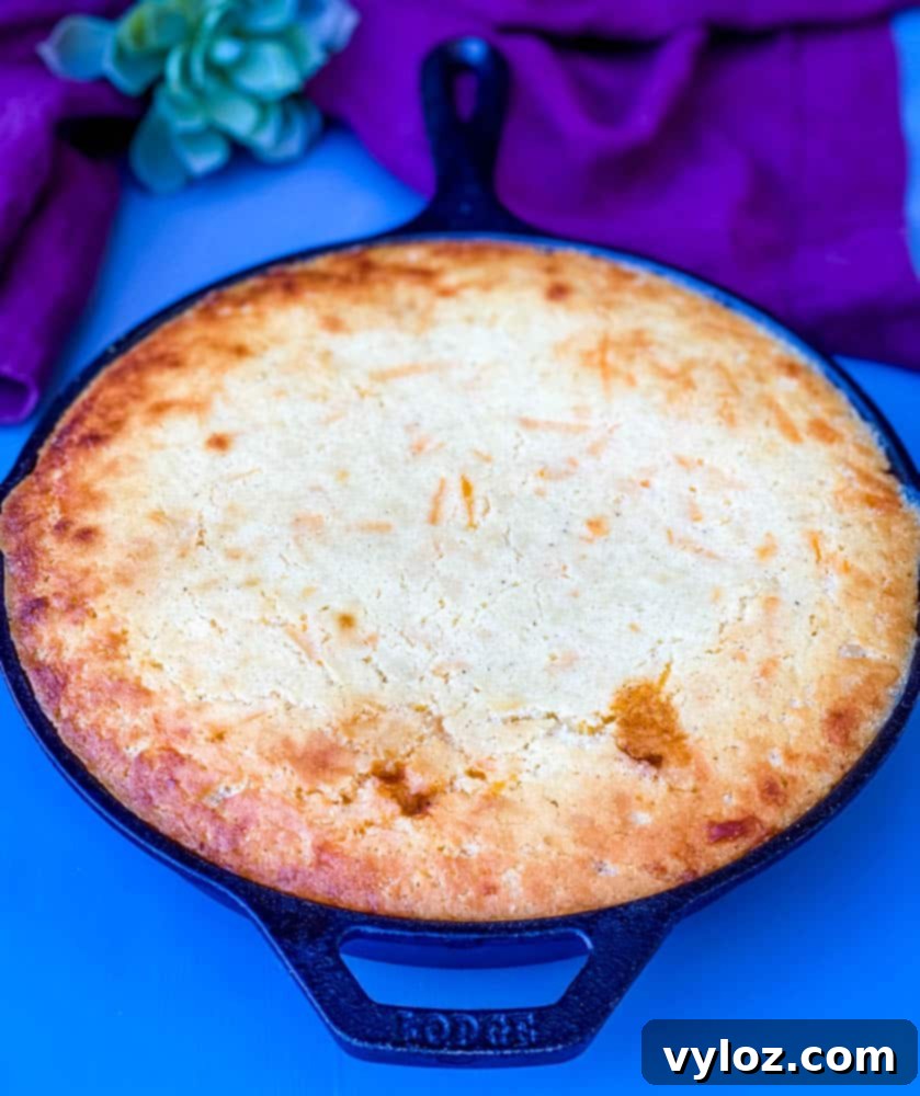 A generous serving of tamale pie, featuring a golden cornbread topping and rich beef chili, presented in a cast iron skillet.