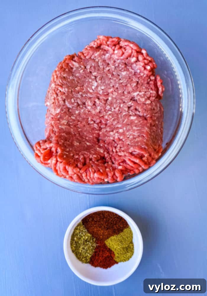 Bowls containing raw ground beef and a blend of chili seasonings, ready for the casserole's flavorful filling.