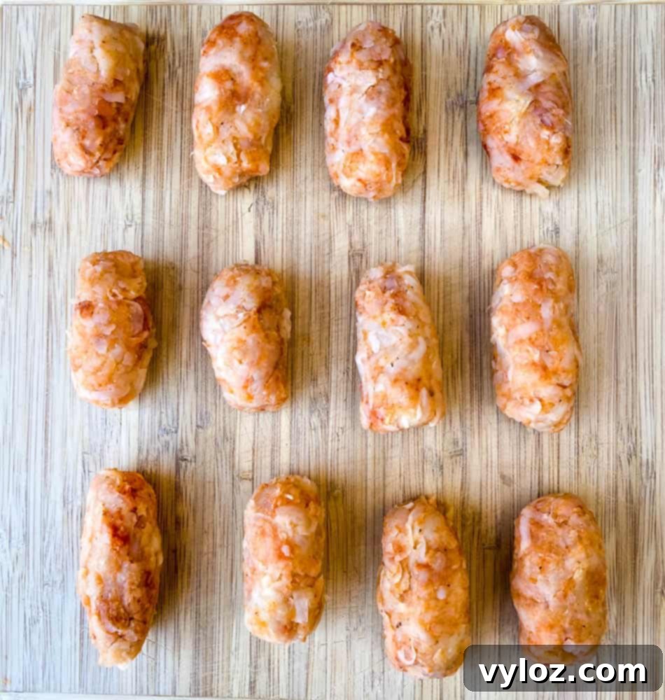 Uncooked homemade air fryer tater tots arranged on a wooden cutting board