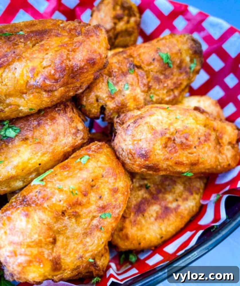 Air fryer tater tots served in a red and white basket with ketchup and chipotle mayo