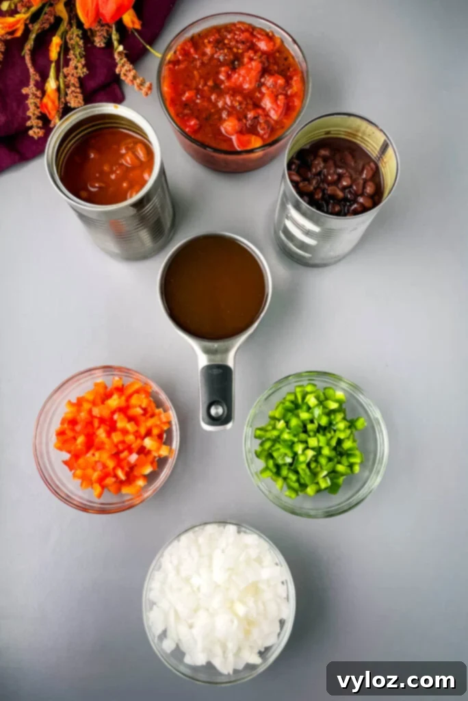 Ultimate Slow Cooker Chili Mac and Cheese 4 chili beans, black beans, beef broth, chopped green peppers, chopped red peppers, fire roasted tomatoes, and chopped onions in separate bowls