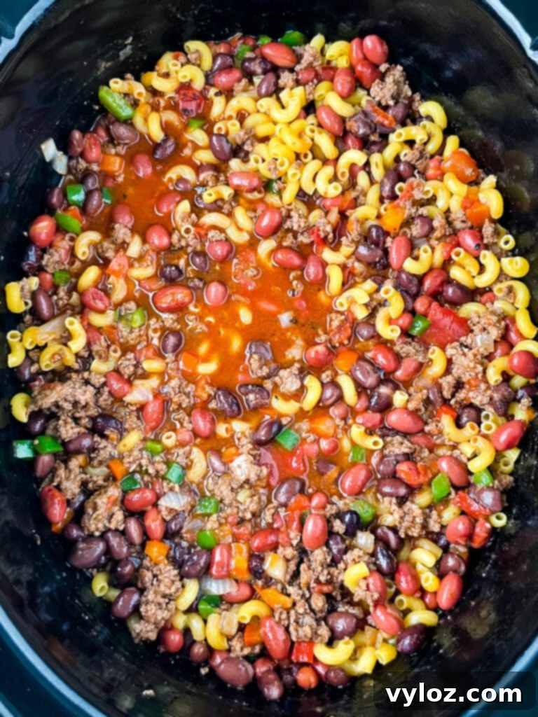 Ultimate Slow Cooker Chili Mac and Cheese 7 uncooked chili mac and cheese in a slow cooker