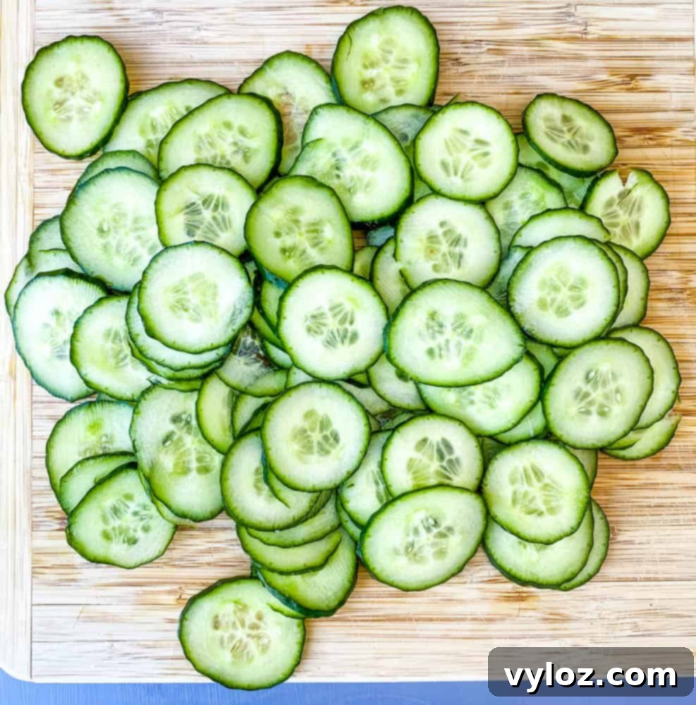 thinly sliced cucumbers on a bamboo cutting board