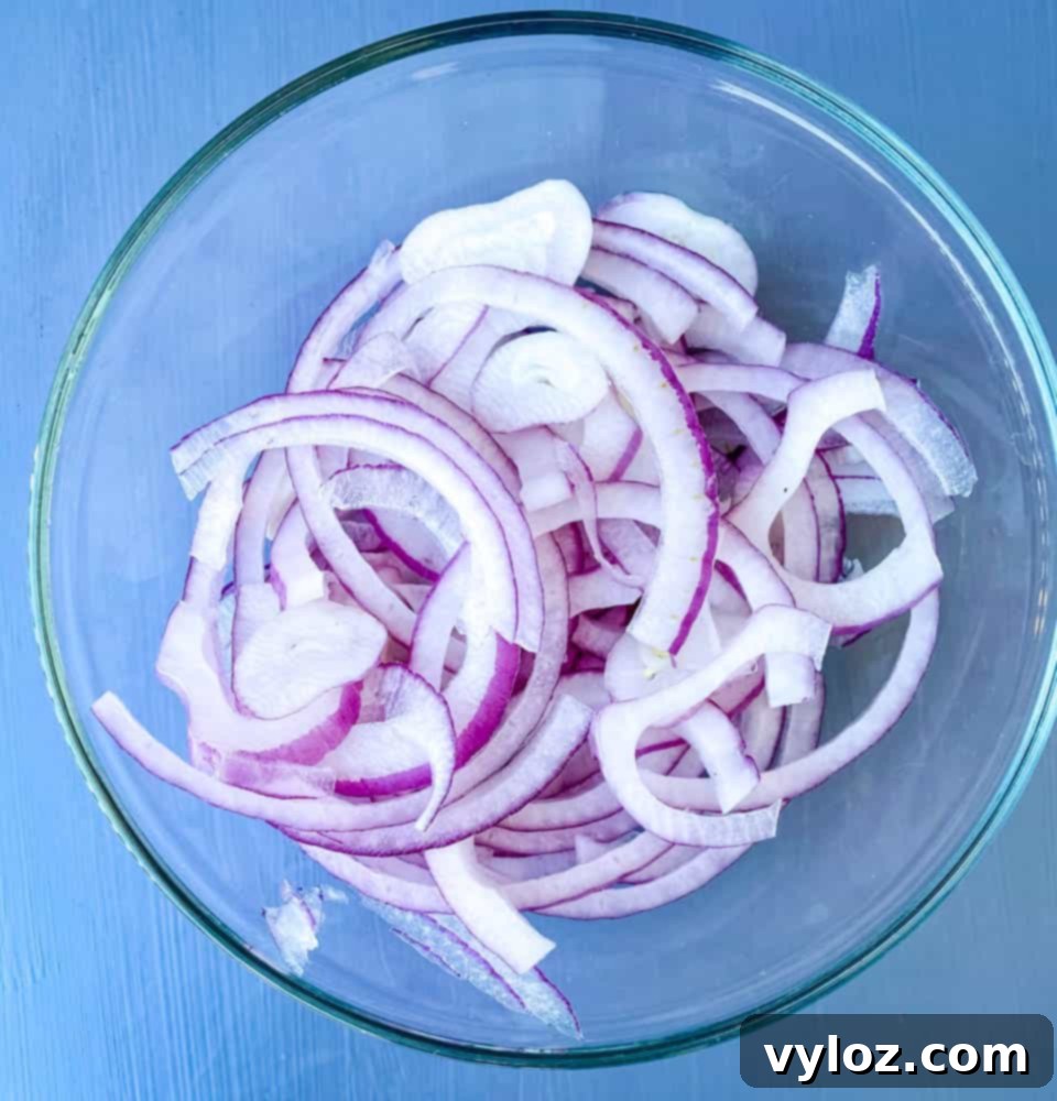 thinly sliced onions in a glass bowl