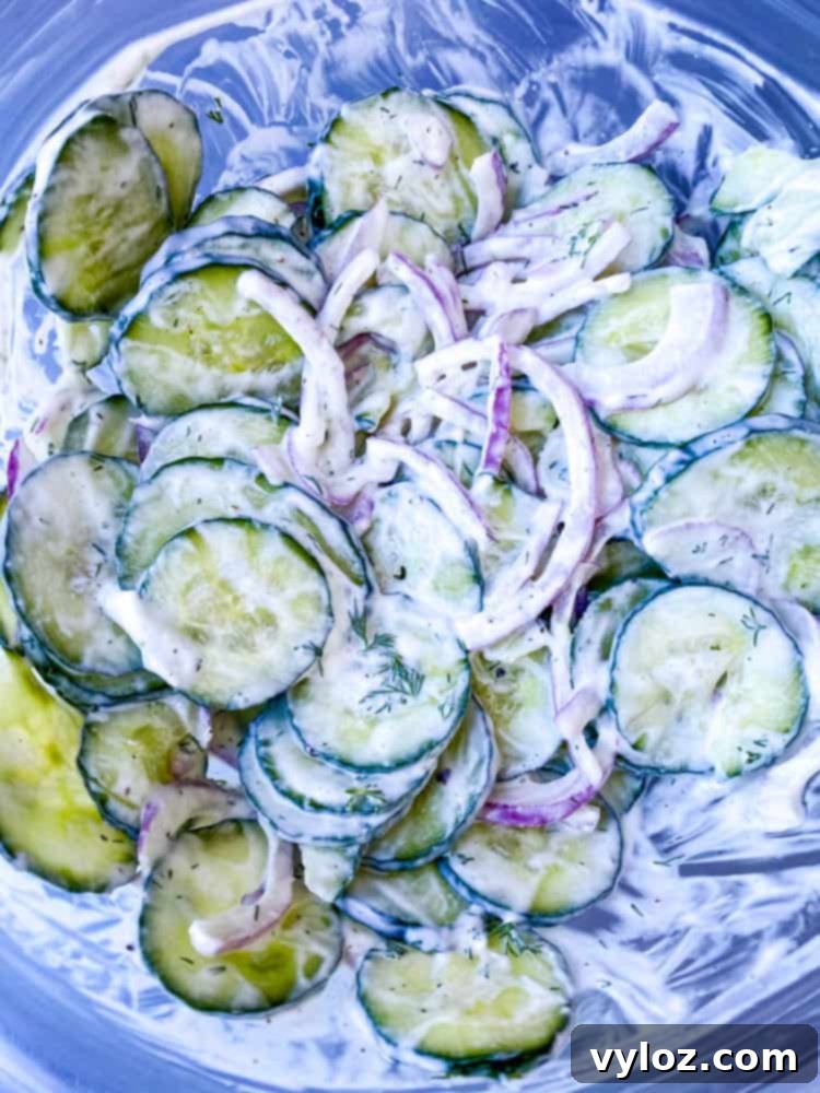 creamy cucumber salad with red onions in a glass bowl