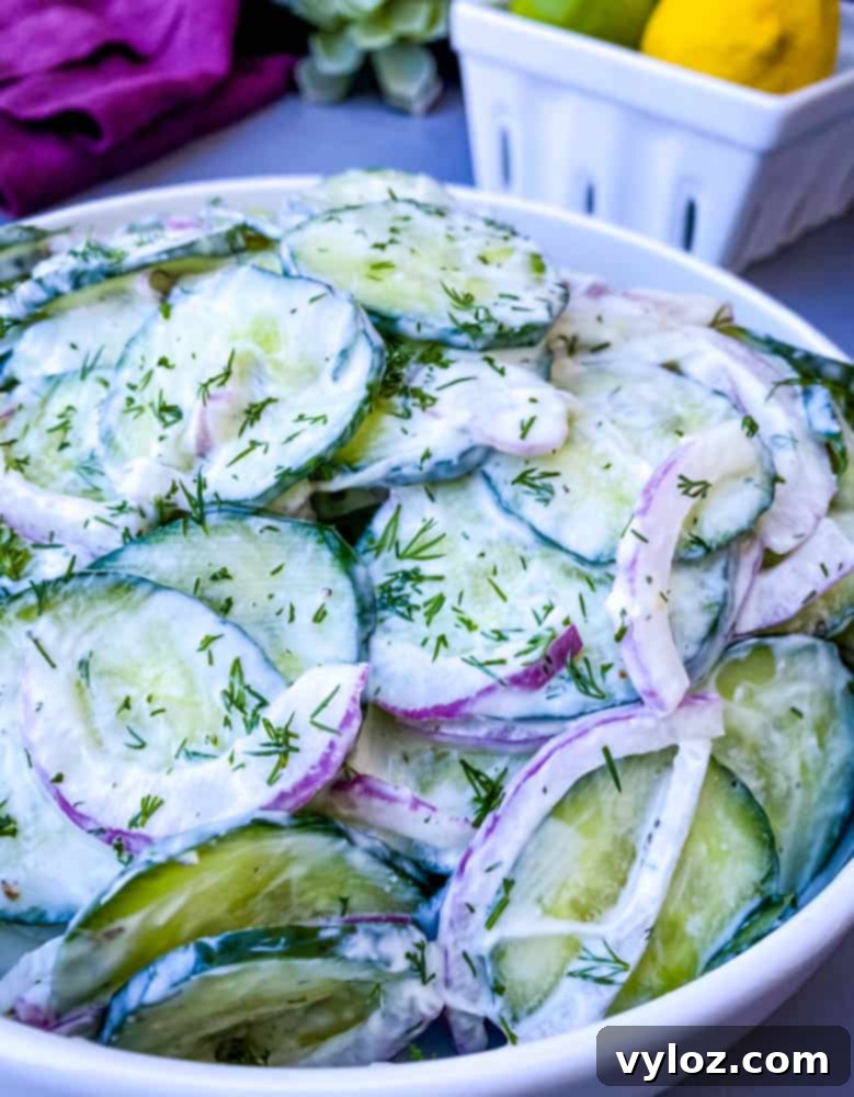 creamy cucumber salad with red onions in a white bowl