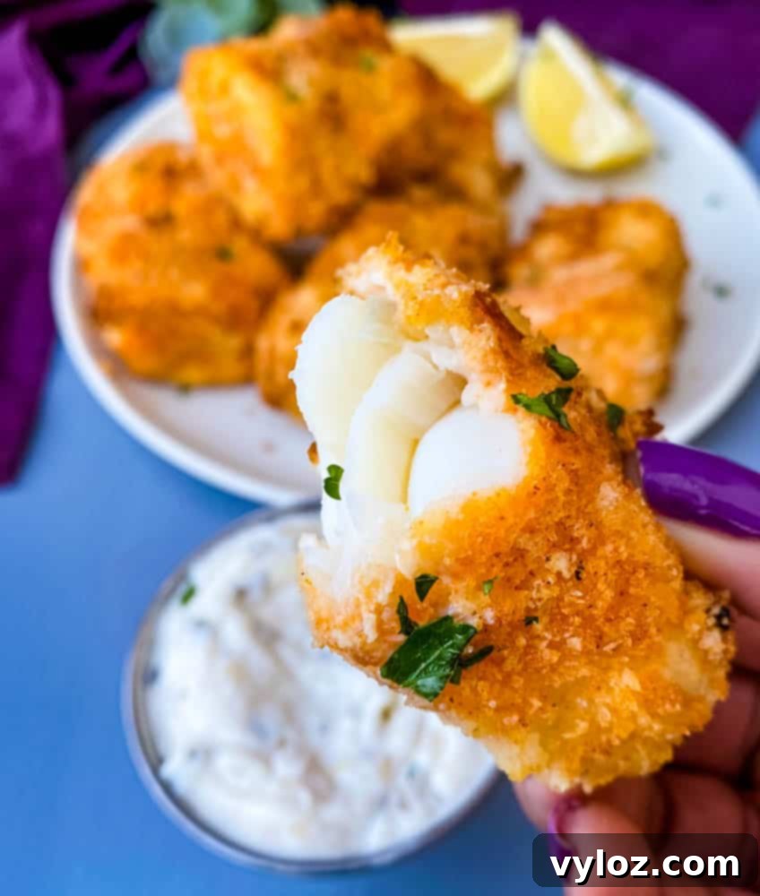 No-Fuss Air Fryer Fish 11 person holding half eaten air fryer fish stick