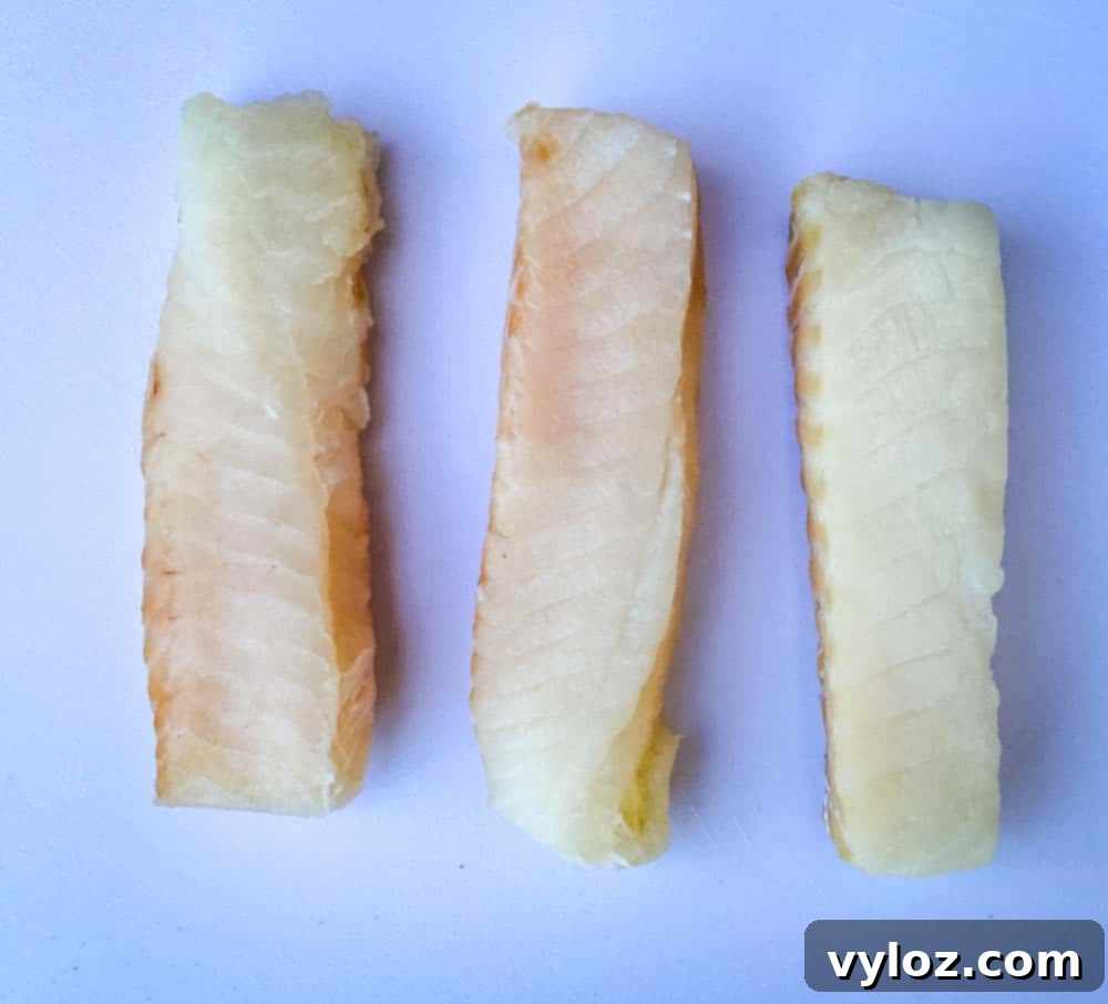 No-Fuss Air Fryer Fish 4 fresh cod fillets on a cutting board