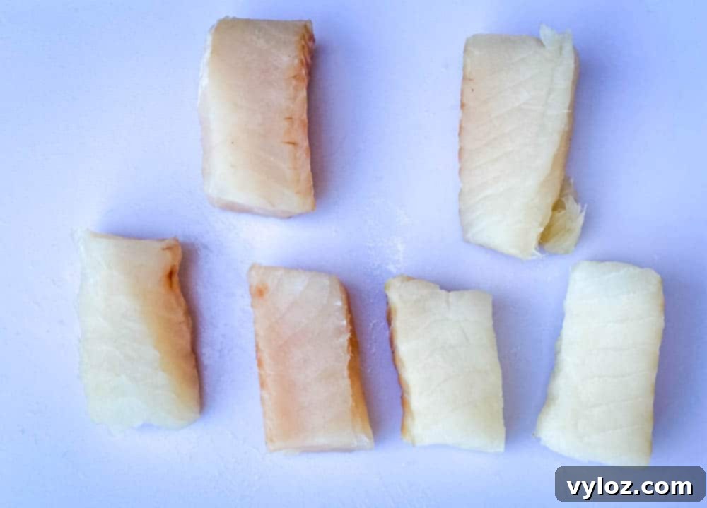 No-Fuss Air Fryer Fish 5 fresh cod fillets on a cutting board