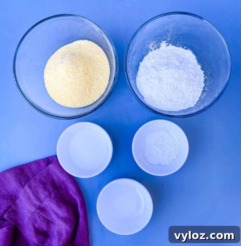 corn meal, all purpose flour, baking powder, sweetener, and salt in separate bowls, ready for corn dog batter