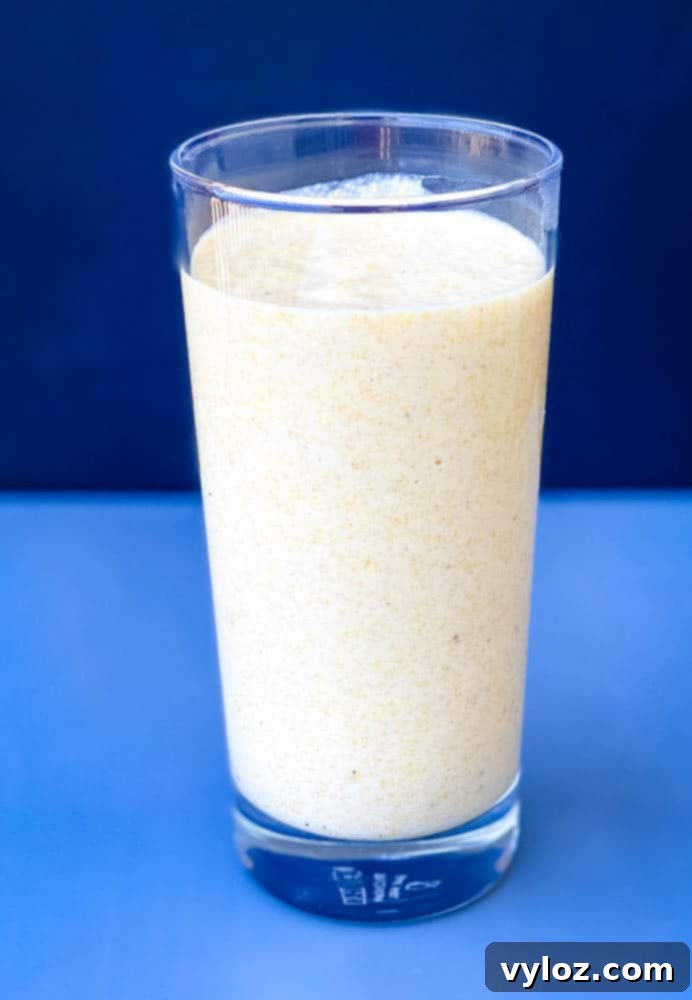 air fryer corn dog batter in a drinking glass, ideal for easy dipping of hot dogs