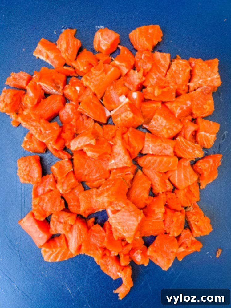 wild caught salmon cut into chunks on a cutting board