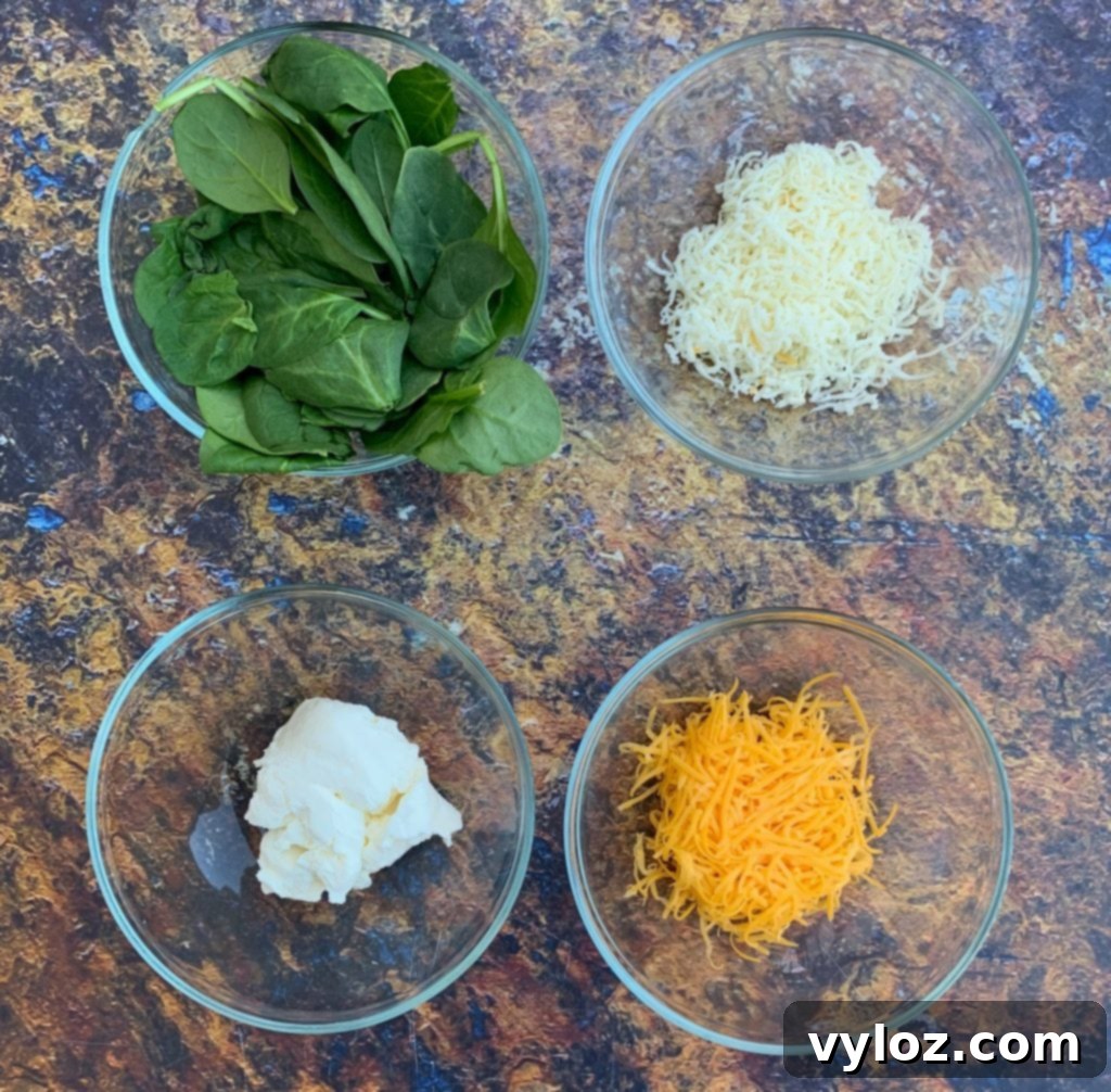 Creamy Spinach Stuffed Chicken Breast 3 Fresh ingredients laid out for making keto low carb stuffed chicken breasts, including raw chicken, spinach, cream cheese, and spices.