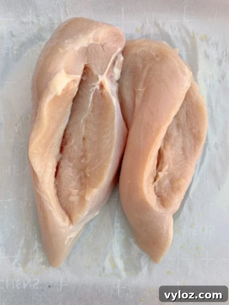 Creamy Spinach Stuffed Chicken Breast 7 Raw chicken breasts, each with a neat side pocket cut, ready to be filled with the spinach cream cheese mixture.