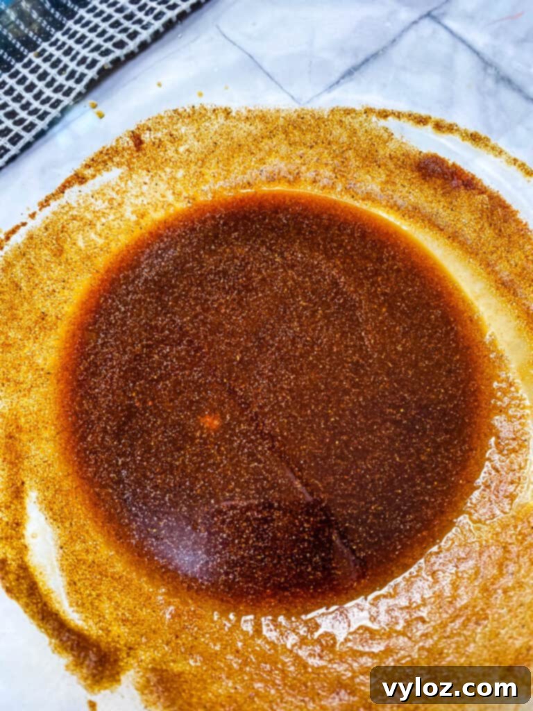 Close-up of the rich beef jerky marinade in a glass bowl, ready for the meat