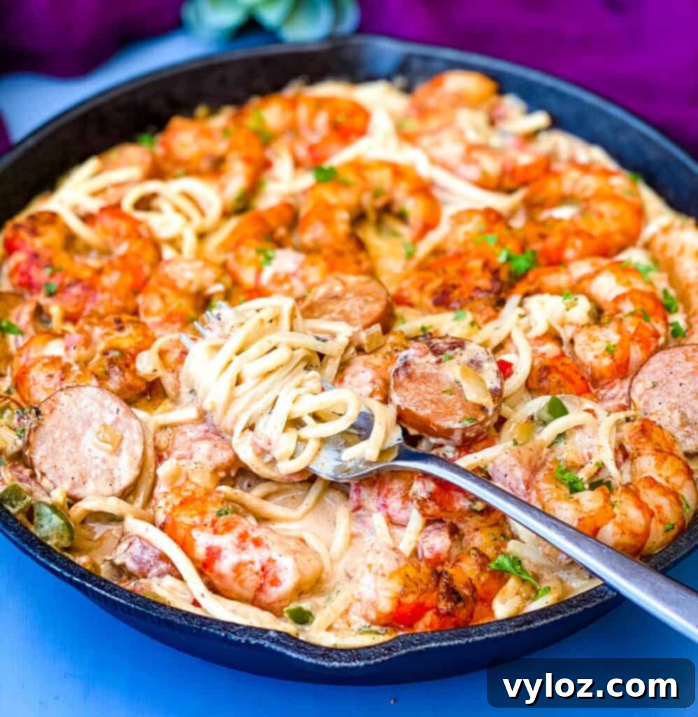 Creamy Cajun Shrimp Pasta in a cast iron skillet, ready to be served, showcasing vibrant shrimp, sausage, and peppers