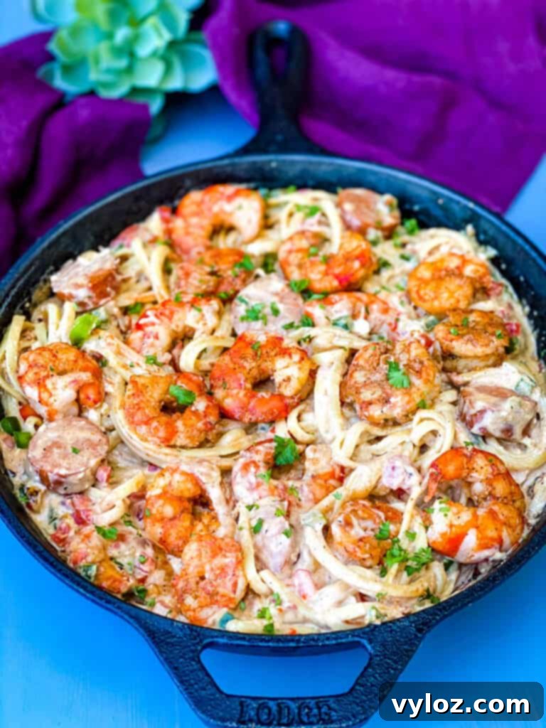 Close-up of Cajun shrimp pasta with linguine in a cast iron skillet, garnished with fresh herbs