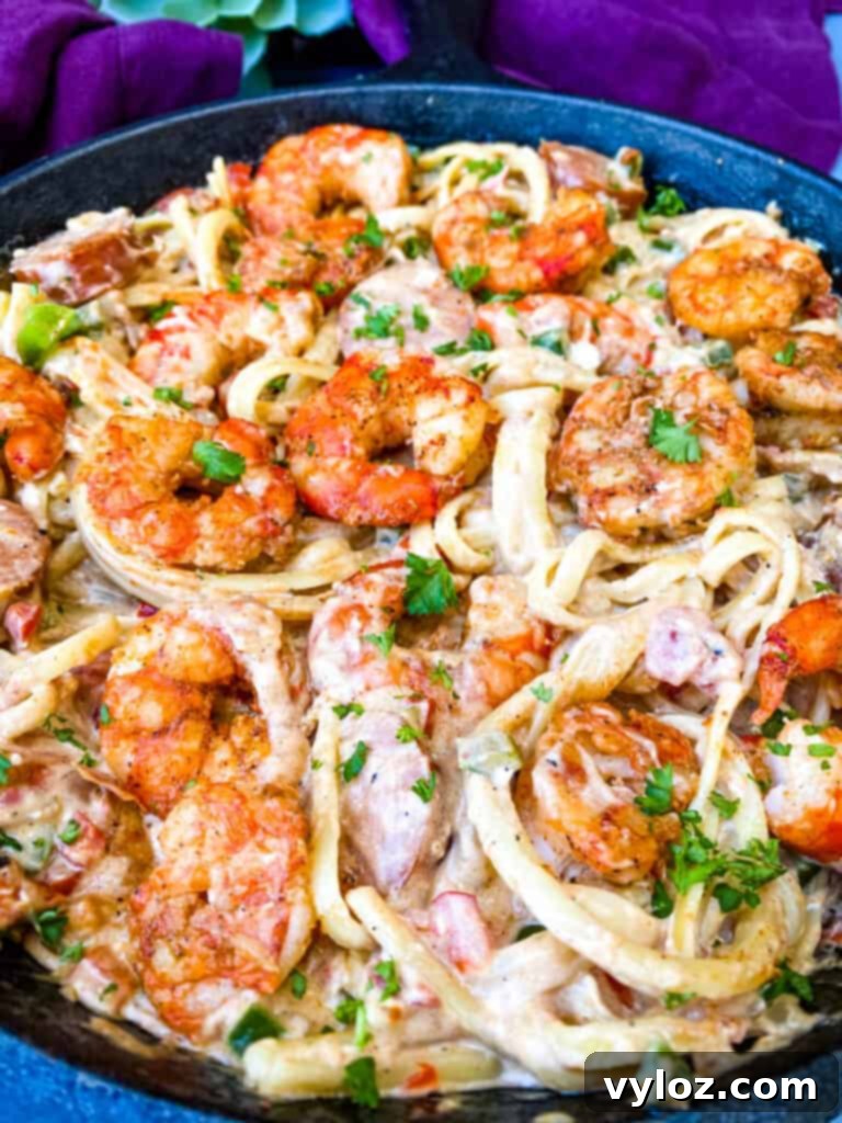 Cajun shrimp pasta garnished with fresh parsley, served in a cast iron skillet