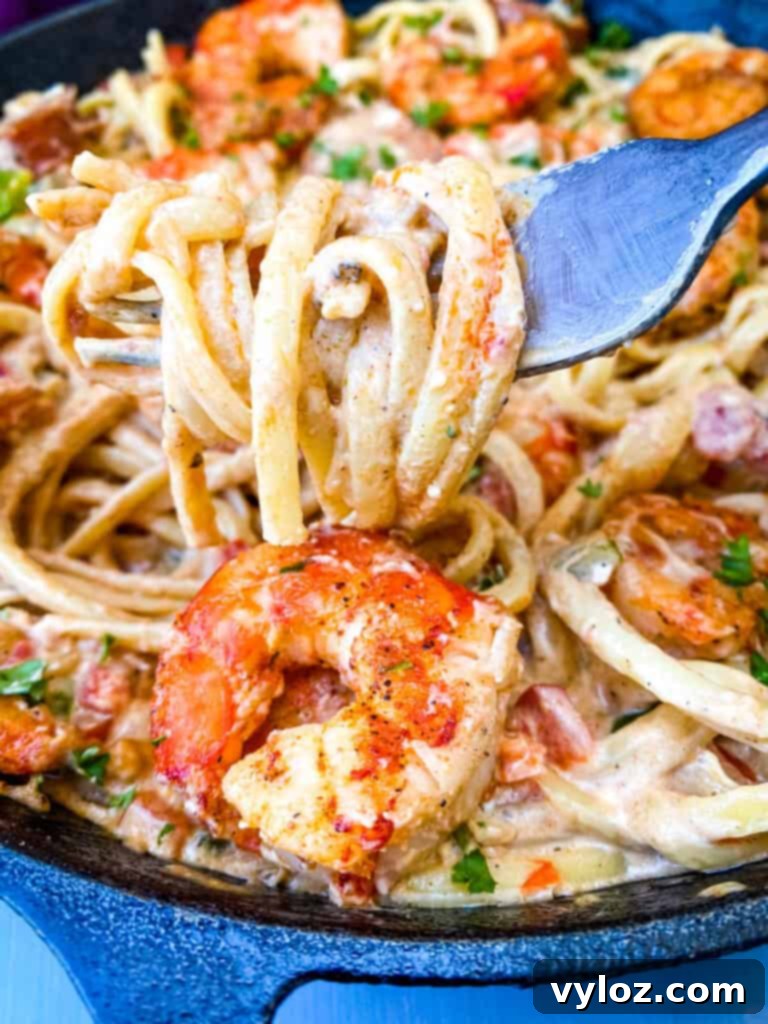 A forkful of creamy Cajun linguine pasta with shrimp, ready to eat