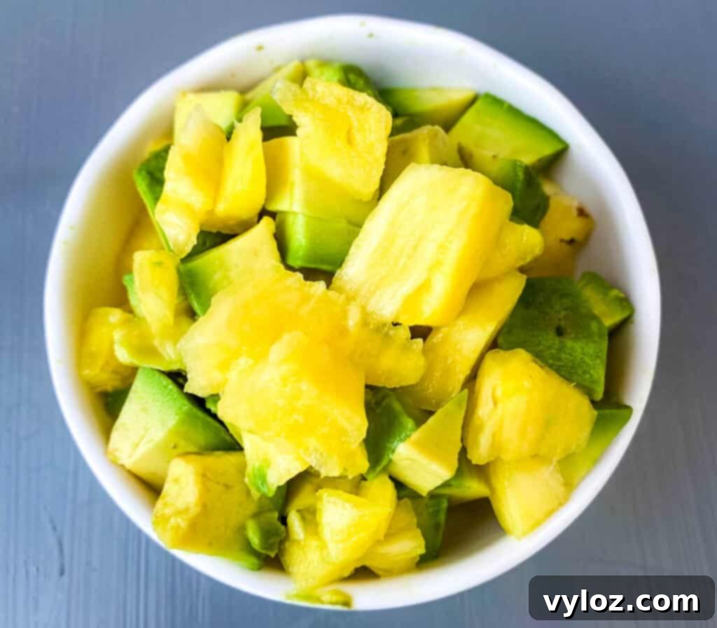 fresh cut pineapple and avocado in a white bowl