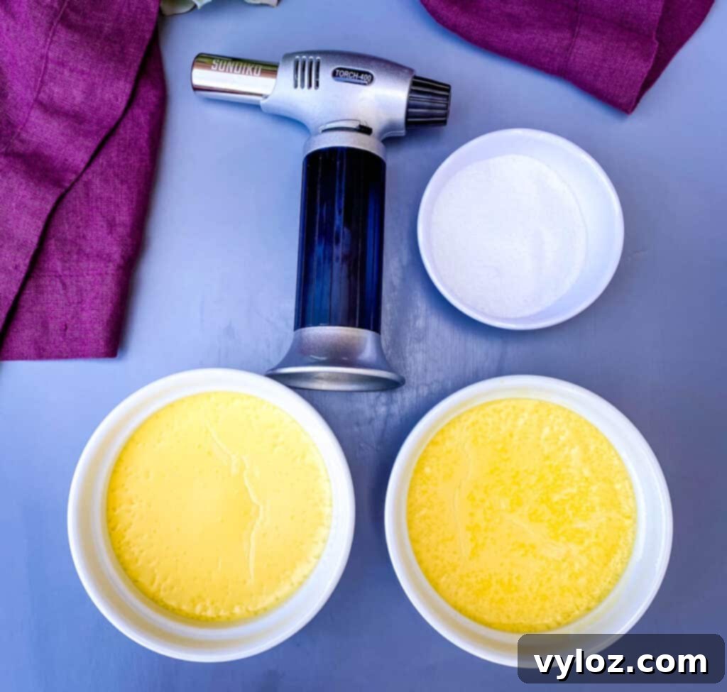 Effortless Keto Crème Brûlée 8 Keto low-carb crème brûlée custard in ramekins, with a kitchen torch positioned next to them, ready for caramelization