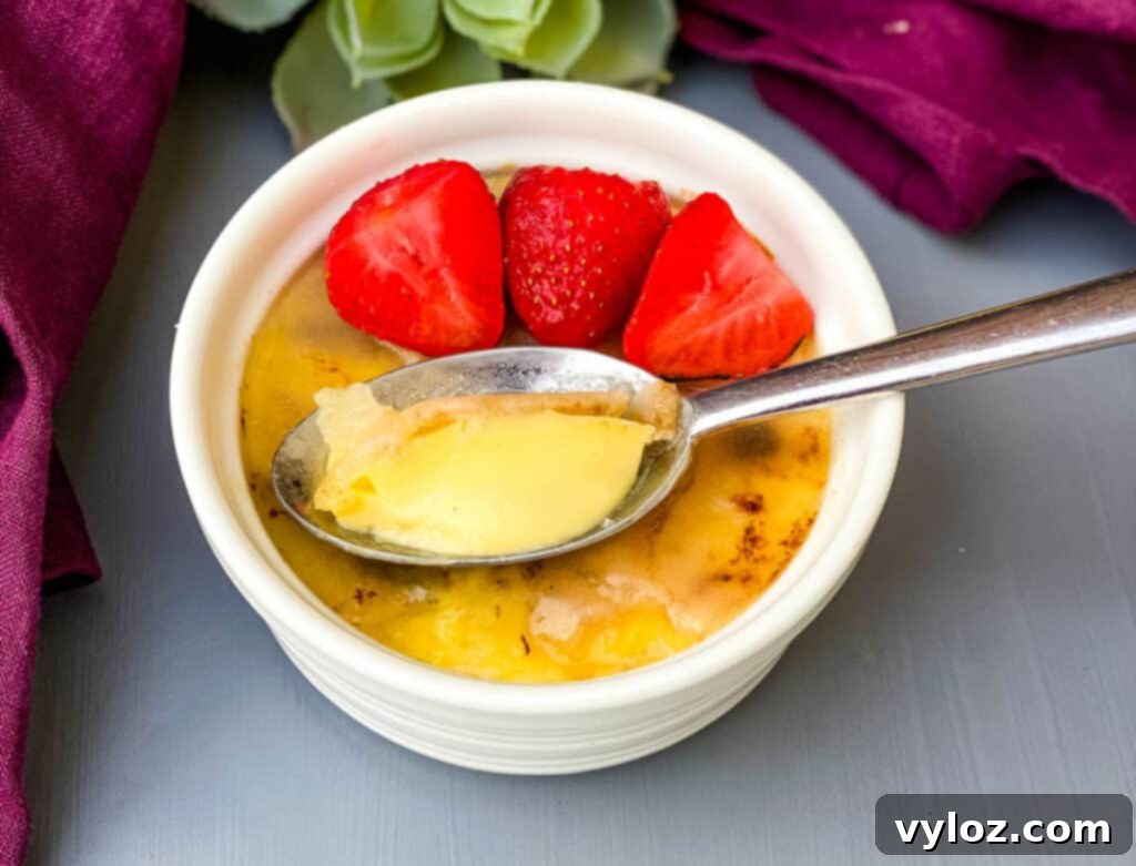 Effortless Keto Crème Brûlée 10 Keto low-carb crème brûlée in a white ramekin, elegantly garnished with fresh strawberries on top