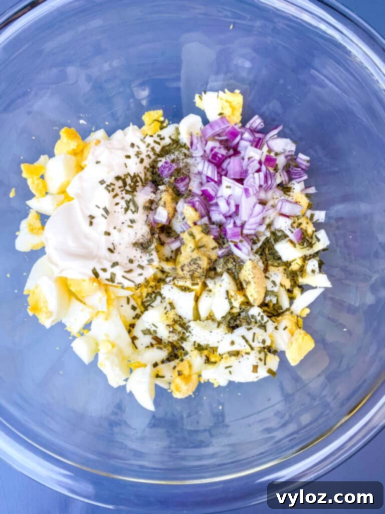 Vibrant Egg Salad 6 chopped boiled eggs, chopped onions, seasoning, mayo and mustard in a glass bowl