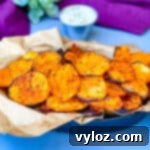 Crispy Air Fryer Sweet Potato Chips 12 Air fryer sweet potato chips in a black bowl with a side of dipping sauce