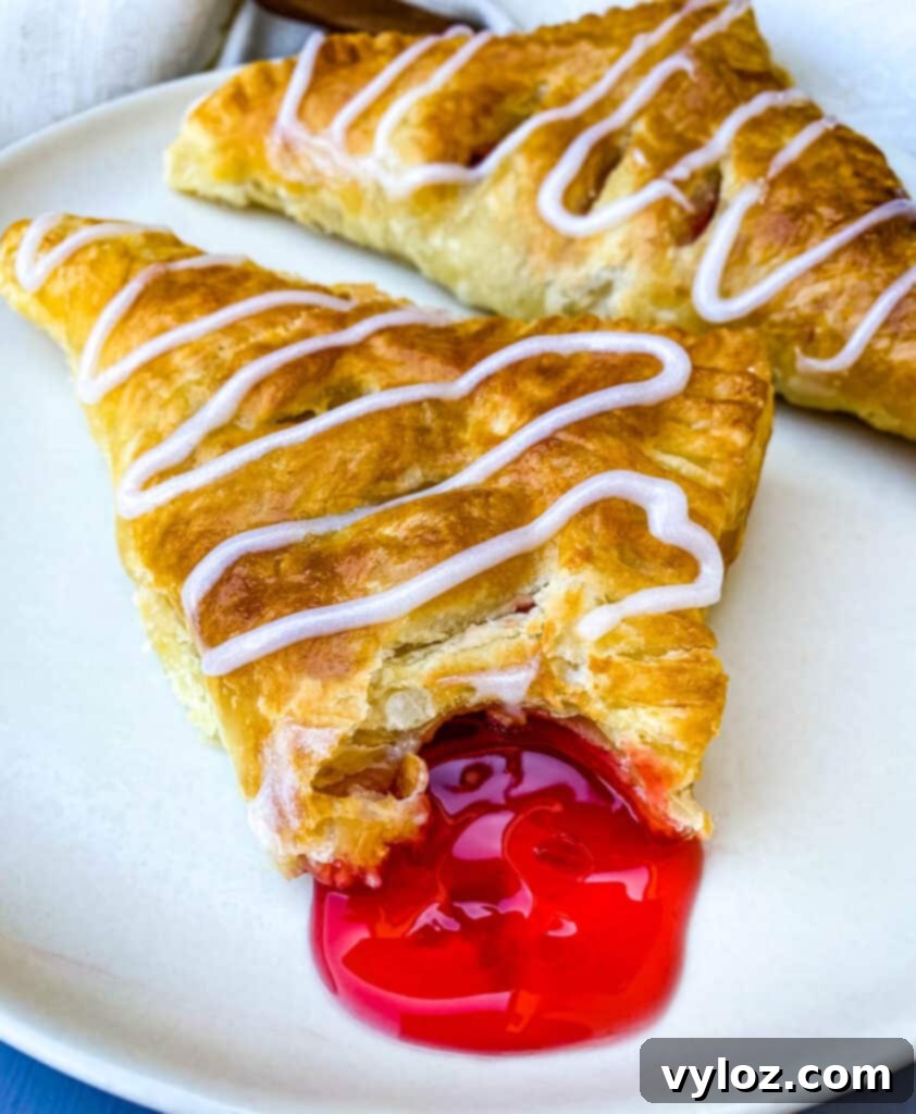 an air fryer turnover on a plate oozing with cherry filling