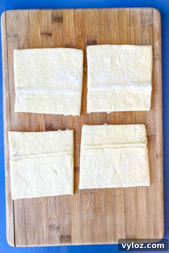 4 sheets of puff pastry on a bamboo cutting board