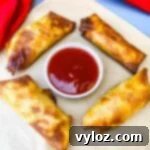 Shrimp egg rolls with sweet and sour sauce on a flat surface