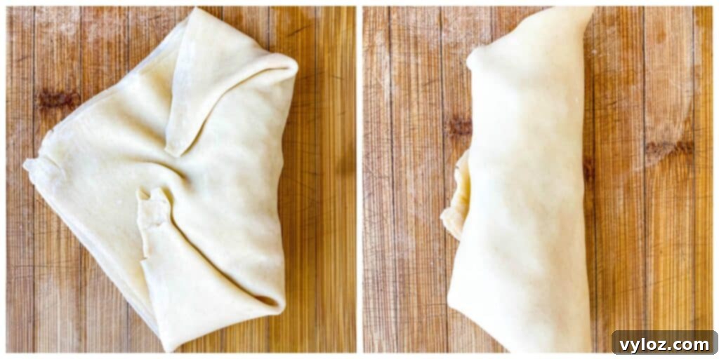 An image showing the partially rolled egg roll, with the sides folded in, demonstrating the next step in the wrapping process.