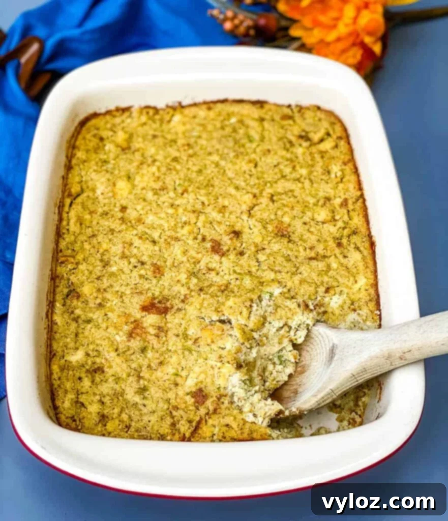 Golden brown Southern cornbread dressing in a rustic baking dish, with a large wooden spoon poised to scoop a generous portion, promising a delicious and comforting meal.