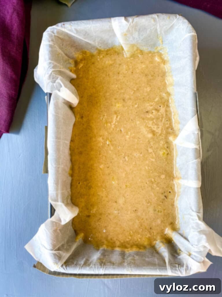 Unbaked healthy banana bread batter in a parchment-lined loaf pan, ready for the oven