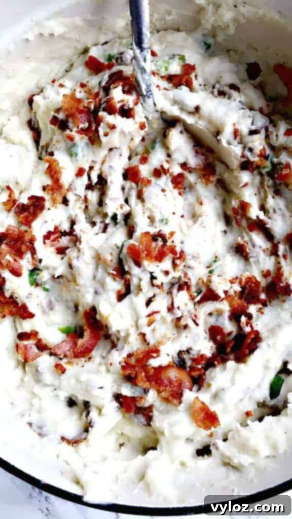 Unpeeled Russet potatoes being added to salted water in a Dutch oven