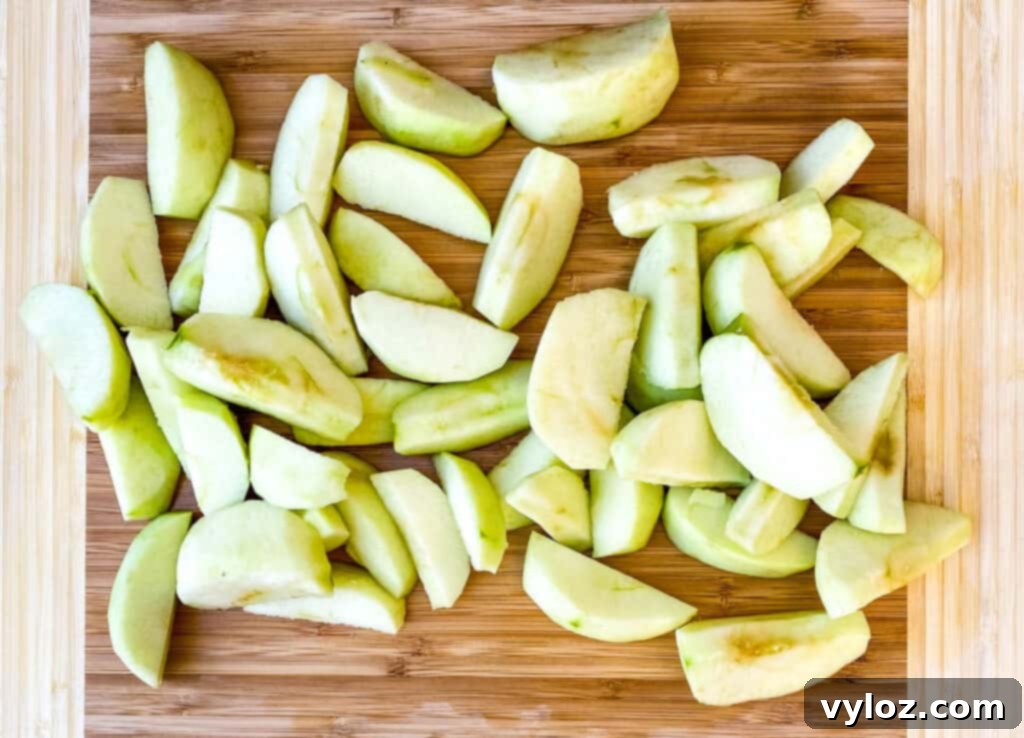 sliced Granny Smith apples on a bamboo cutting board