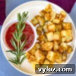Crispy Air Fryer Roasted Potatoes 10 air fryer roasted potatoes on a white plate with ketchup