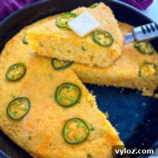 Zesty Cheddar Jalapeño Cornbread 11 jalapeno cheddar cornbread with butter in a cast iron skillet