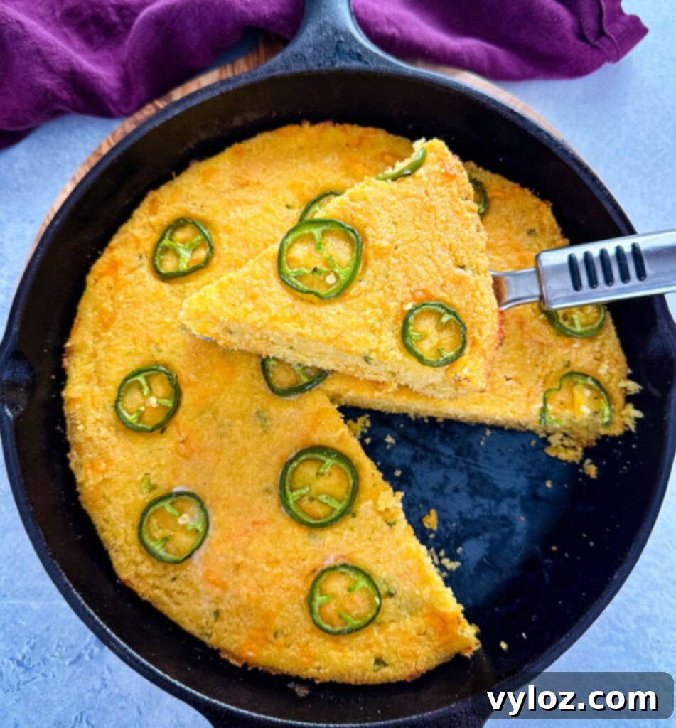 Zesty Cheddar Jalapeño Cornbread 8 jalapeno cheddar cornbread with butter in a cast iron skillet