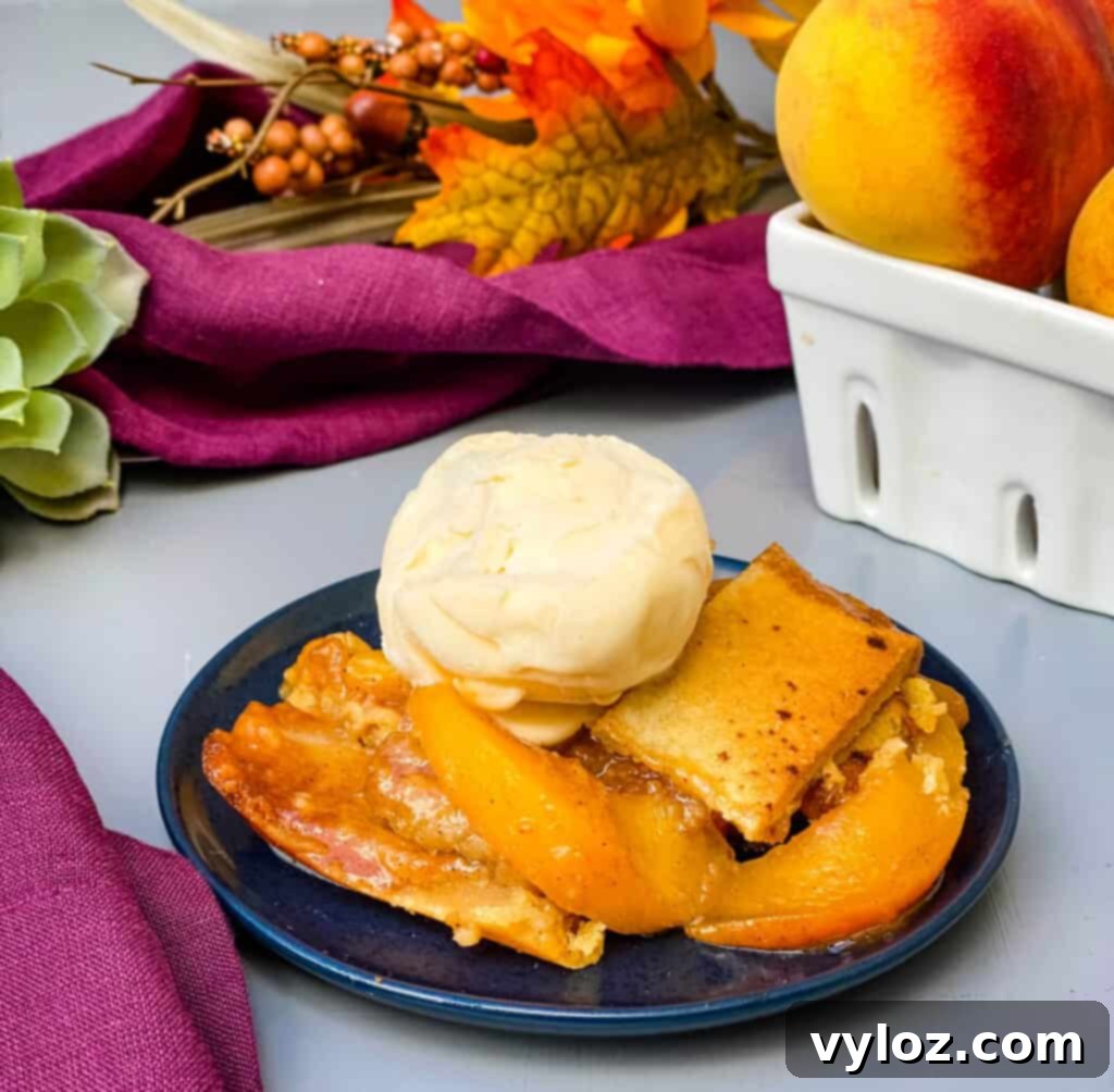 Healthy Southern Peach Cobbler on a blue plate with vanilla ice cream, ready to be enjoyed