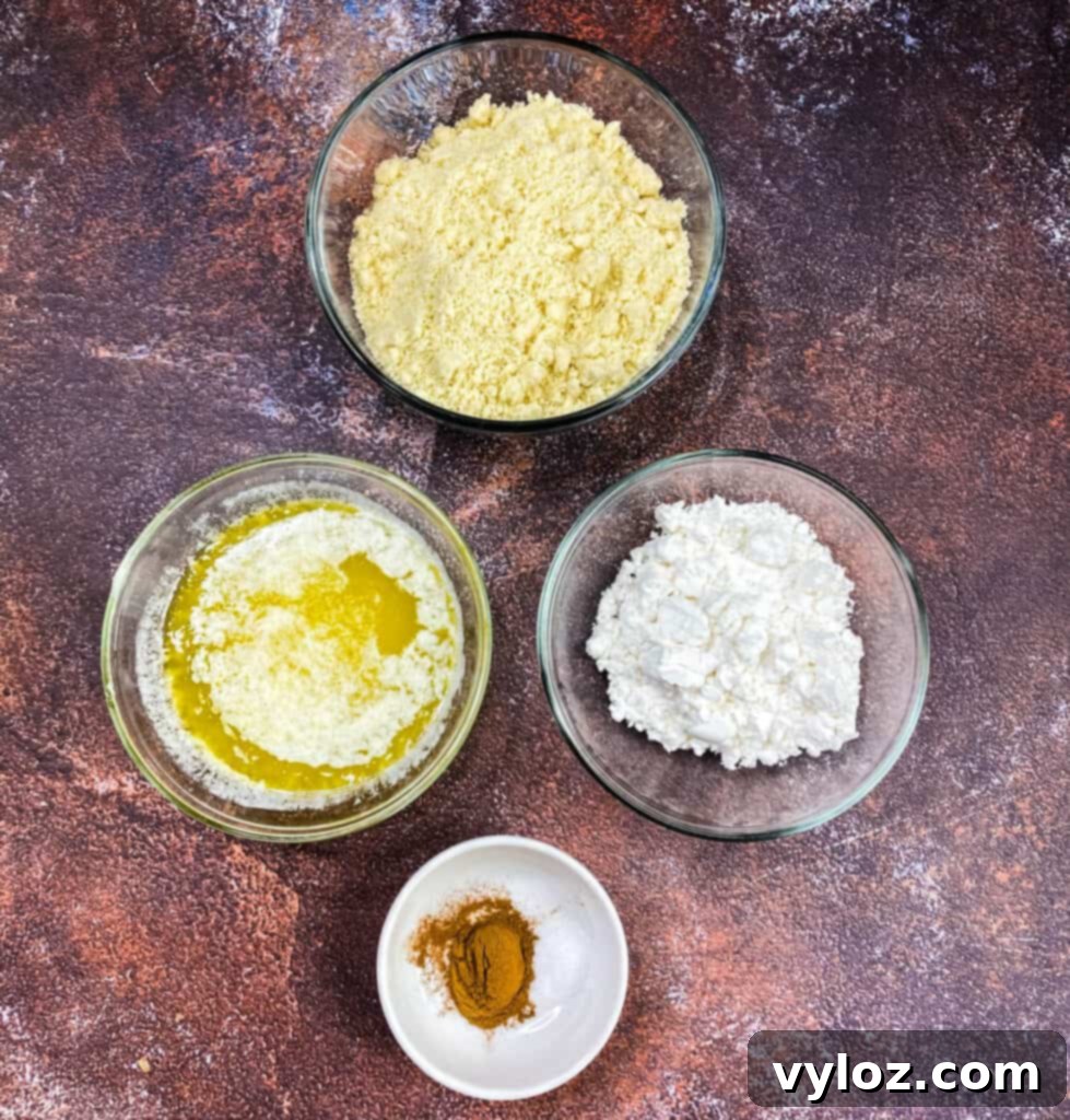 Almond flour, melted butter, powdered sweetener, and cinnamon in glass bowls